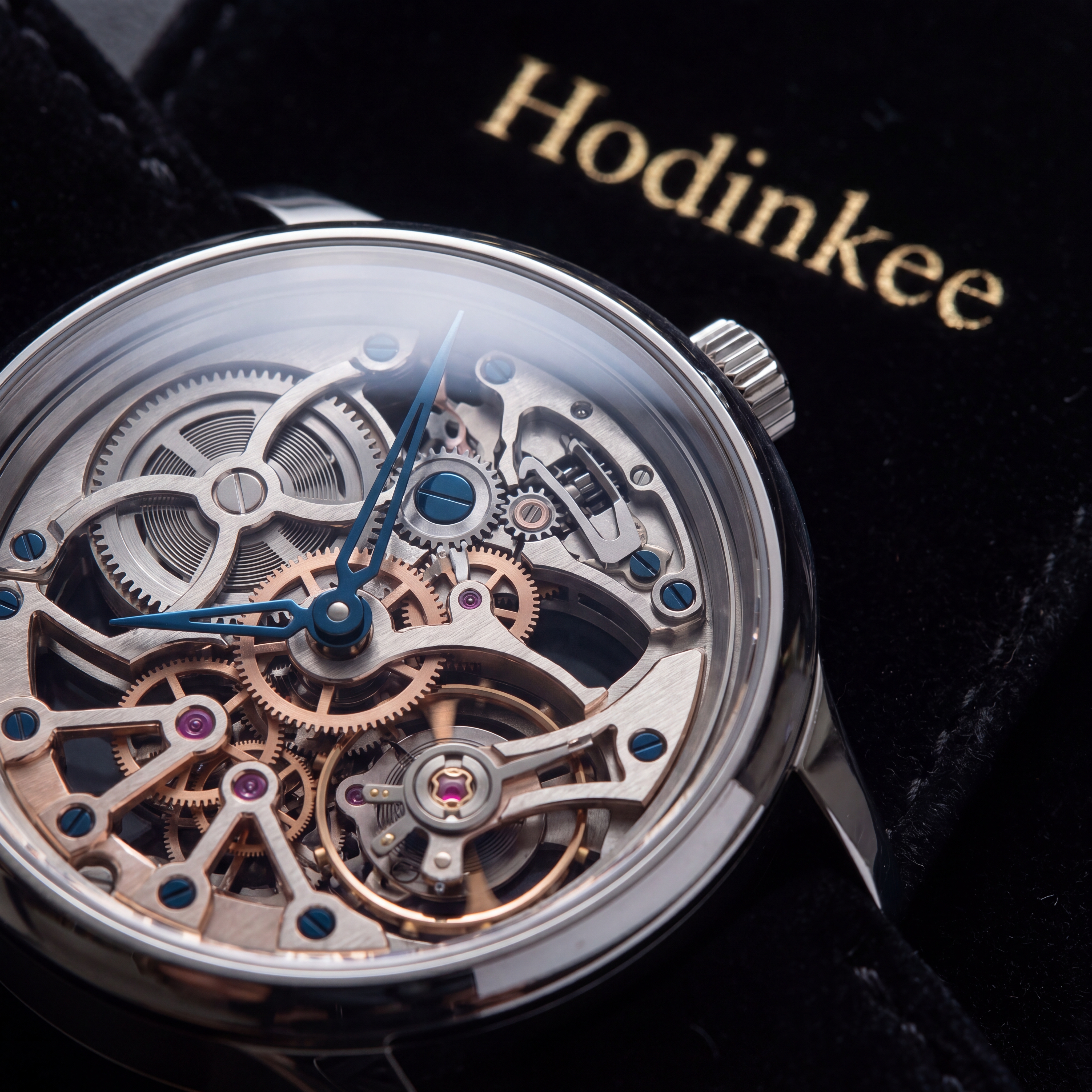 Ultra high-end studio product photograph of a luxury mechanical skeleton watch resting on black Italian velvet, macro lens view revealing exposed gears and ruby bearings, sapphire crystal catching a sharp rim-light reflection, shallow depth of field, commercial photography for Hodinkee, razor-detailed materials